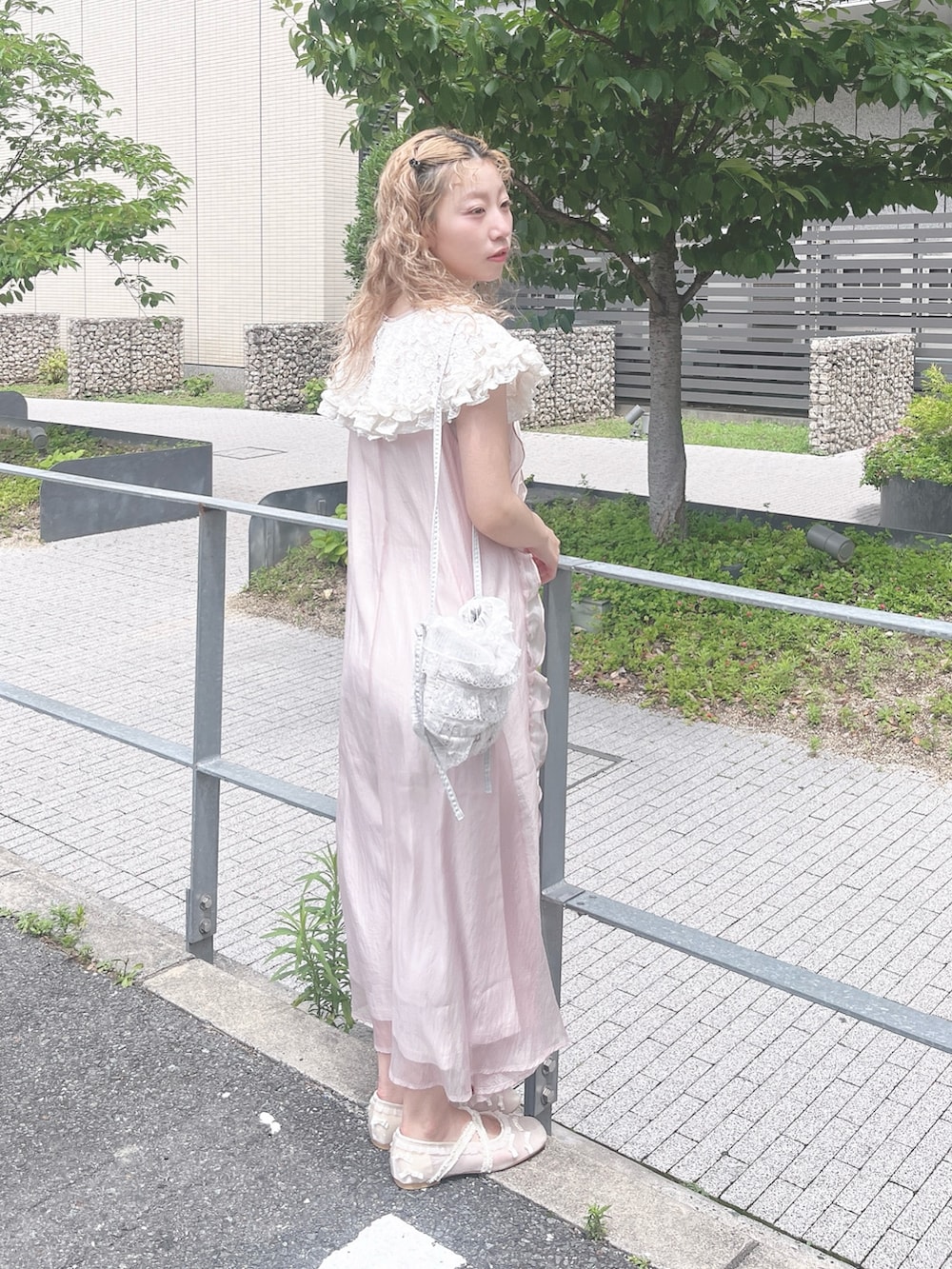 ピンク系のワンピース、ホワイト系のバレエシューズ、ブルー系のショルダーバッグを着用したレディースの夏コーディネートの3枚目の写真