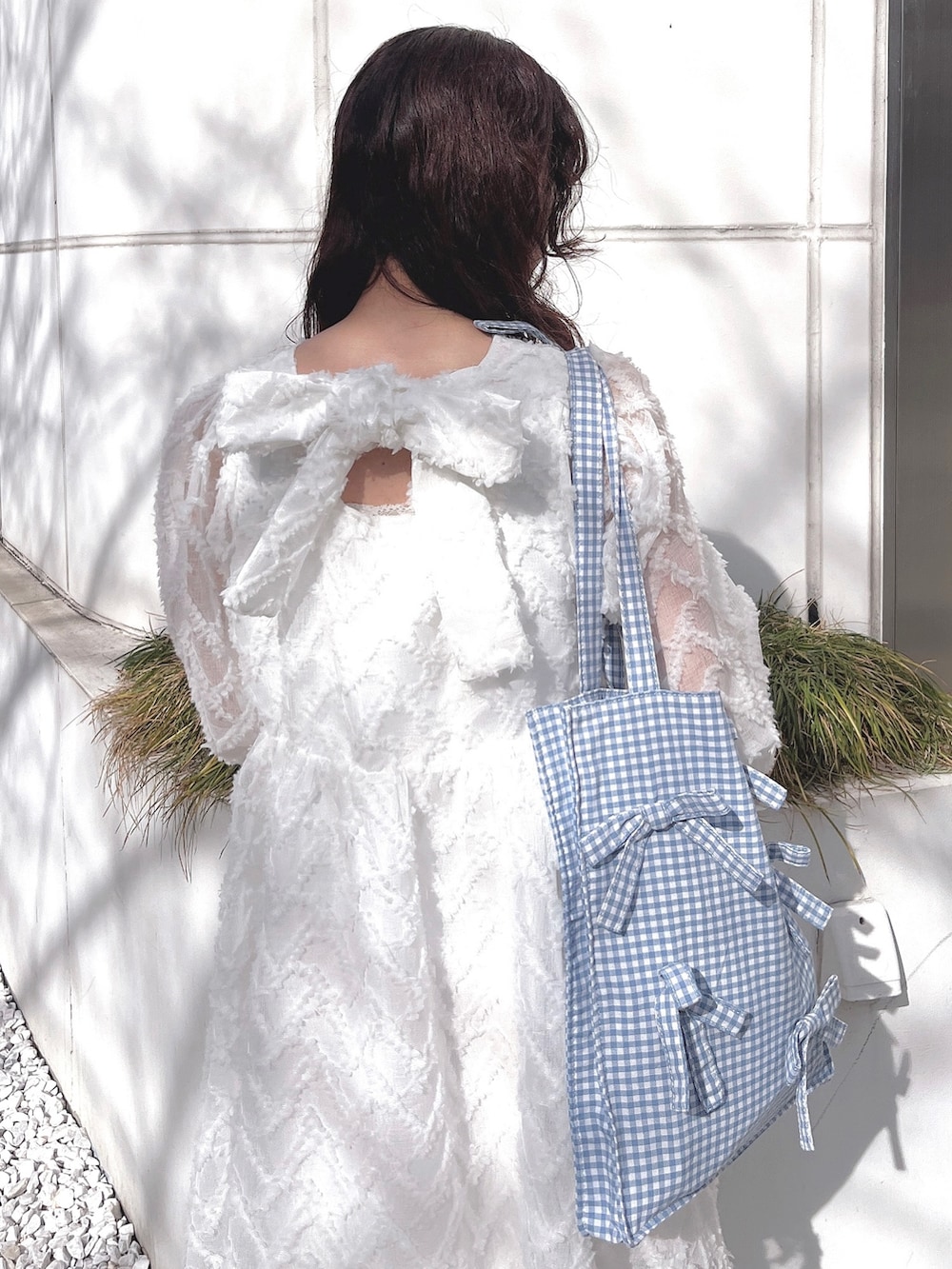 ホワイト系のワンピース、ブルー系のトートバッグ、ホワイト系のバレエシューズを着用したレディースの冬コーディネートの8枚目の写真