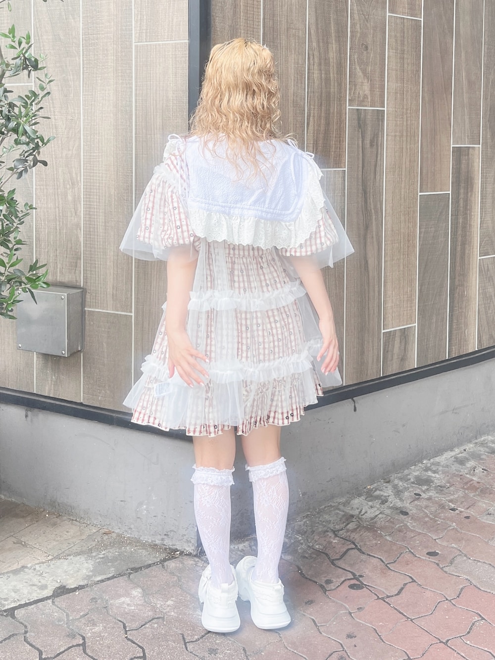 ホワイト系のチュニック、ホワイト系のショルダーバッグ、レッド系のワンピースを着用したレディースの夏コーディネートの3枚目の写真