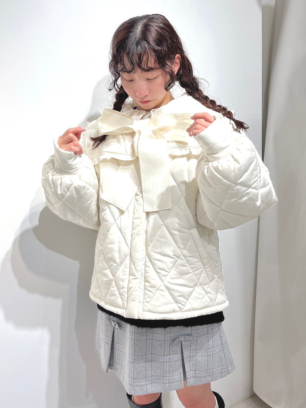 ブラック系のニット/セーター、ホワイト系のダウンジャケット/コート、グレー系のスカートを着用したレディースの冬コーディネートの3枚目の写真