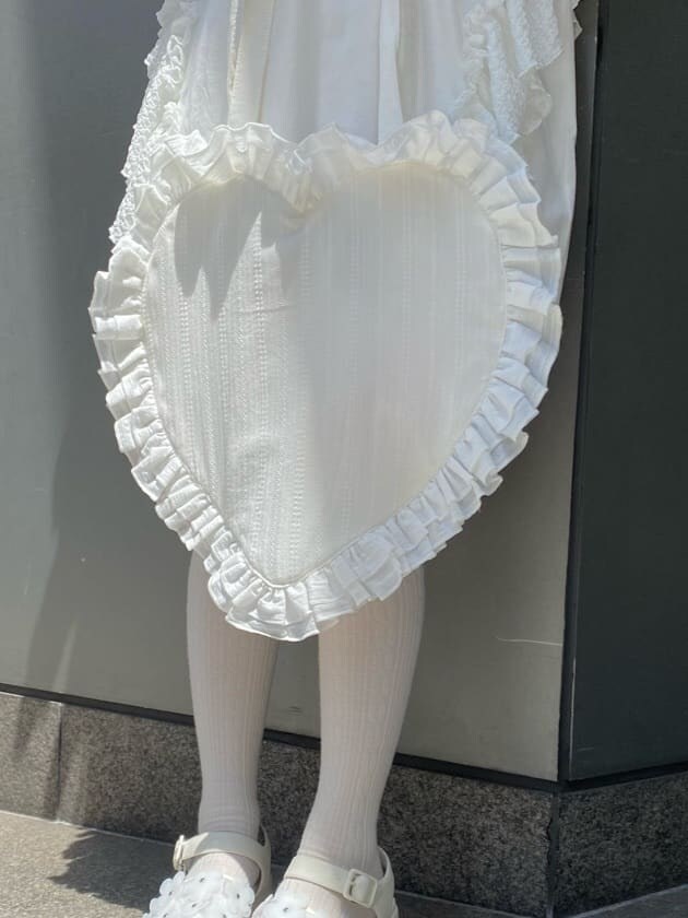 ホワイト系のチュニック、ホワイト系のその他パンツ、ホワイト系のサンダルを着用したレディースの春コーディネートの6枚目の写真