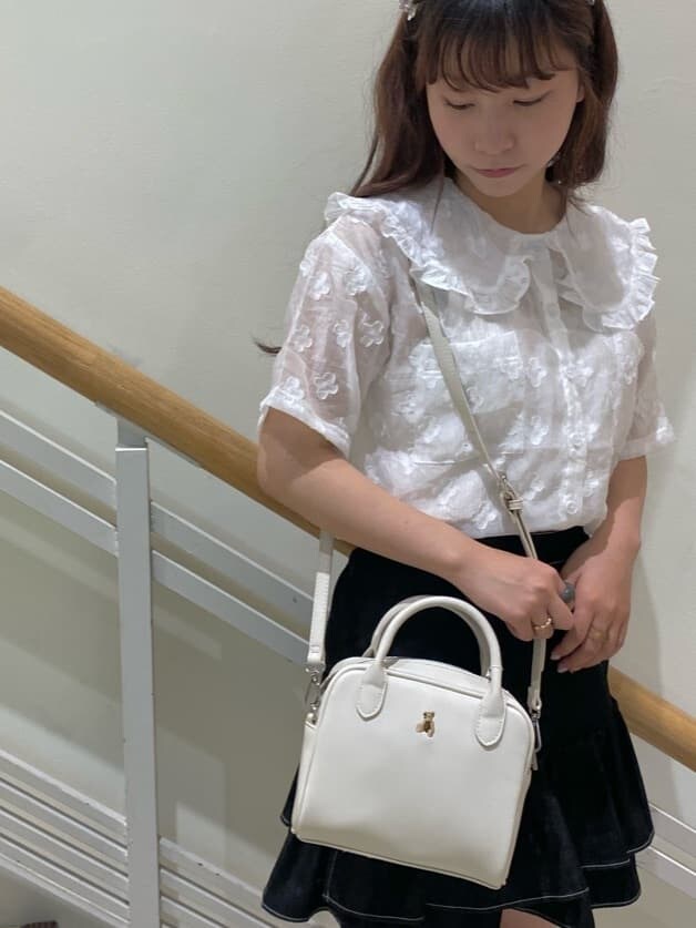 ブラック系のスカート、ホワイト系のサンダル、ホワイト系のショルダーバッグを着用したレディースの春コーディネートの6枚目の写真