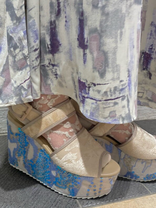 パープル系のシャツ/ブラウス、パープル系のスカート、ブルー系のサンダルを着用したレディースの冬コーディネートの6枚目の写真