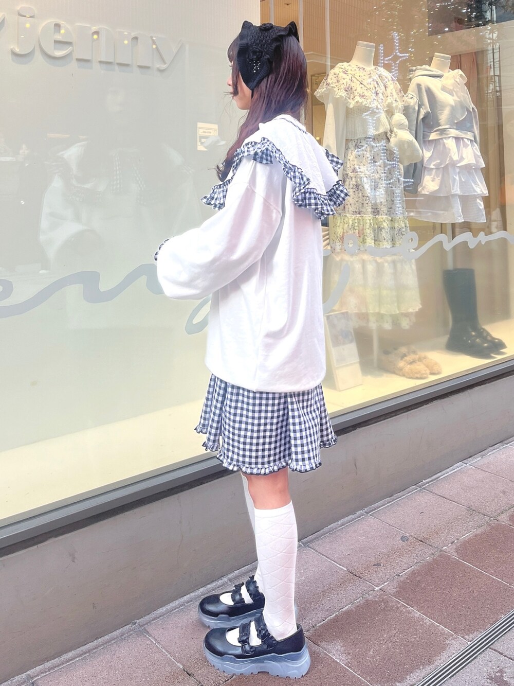 ホワイト系のスウェット、ブラック系のワンピース、ブラック系のスニーカーを着用したレディースの冬コーディネートの4枚目の写真