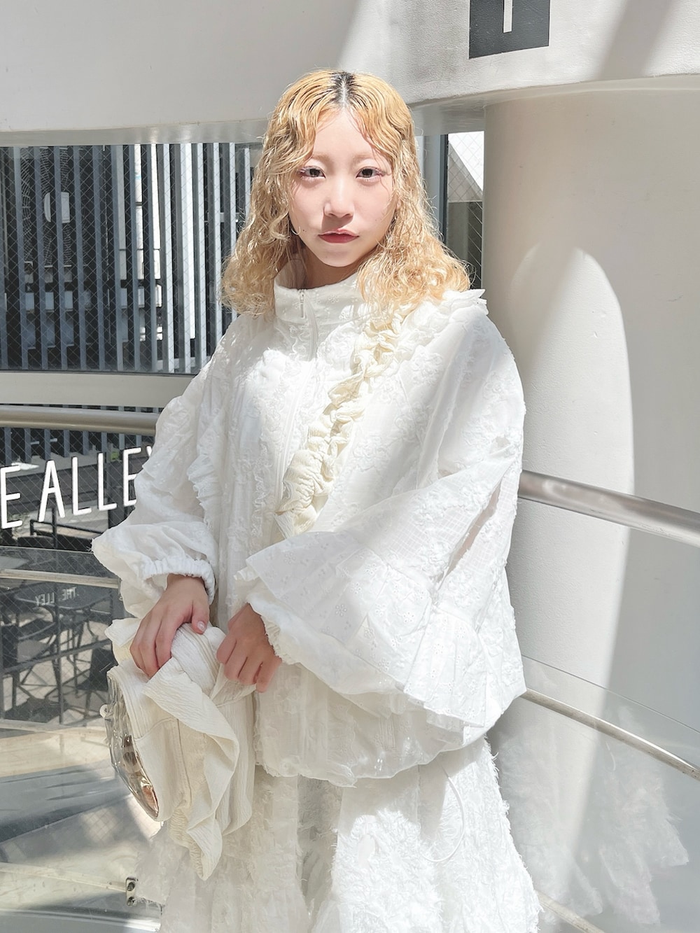 ホワイト系のブルゾン、ホワイト系のショルダーバッグ、ホワイト系のワンピースを着用したレディースの夏コーディネートの3枚目の写真