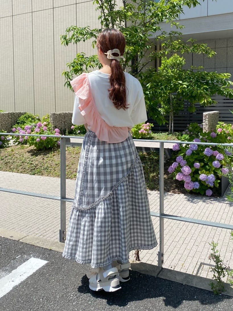 グレー系のスカート、ホワイト系のTシャツ/カットソー、ホワイト系のショルダーバッグを着用したレディースの夏コーディネートの2枚目の写真