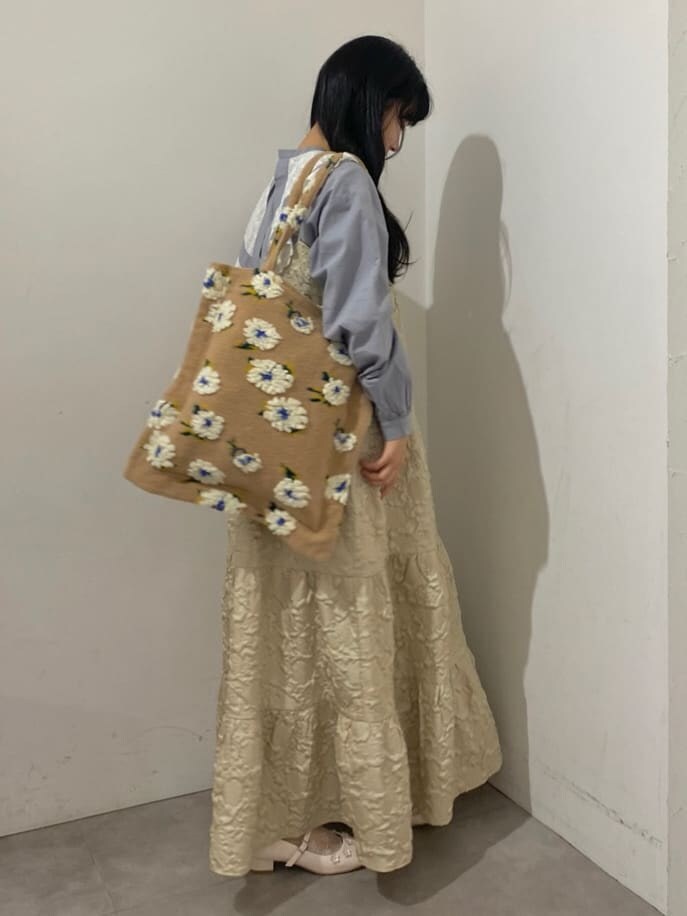 ホワイト系のパンプス、ベージュ系のワンピース、ベージュ系のトートバッグを着用したレディースの秋コーディネートの3枚目の写真