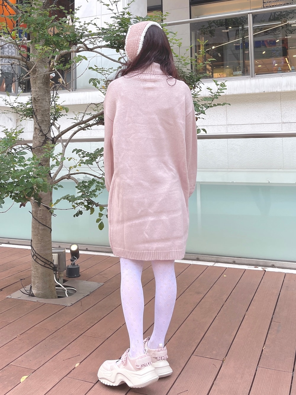 ピンク系のワンピース、ピンク系のスニーカー、ピンク系のイヤーマフを着用したレディースの秋コーディネートの4枚目の写真