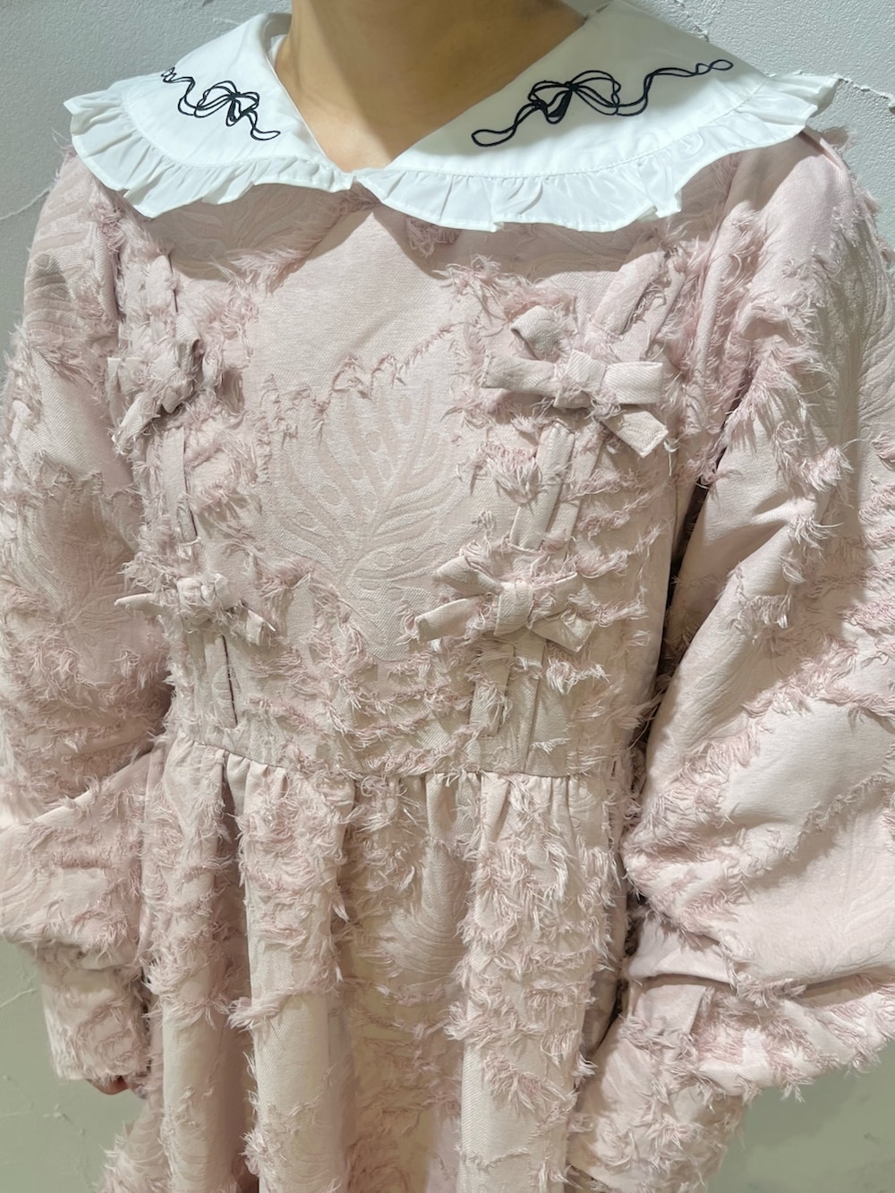 ピンク系のワンピース、ホワイト系のシャツ/ブラウス、ホワイト系のブーツを着用したレディースの秋コーディネートの8枚目の写真