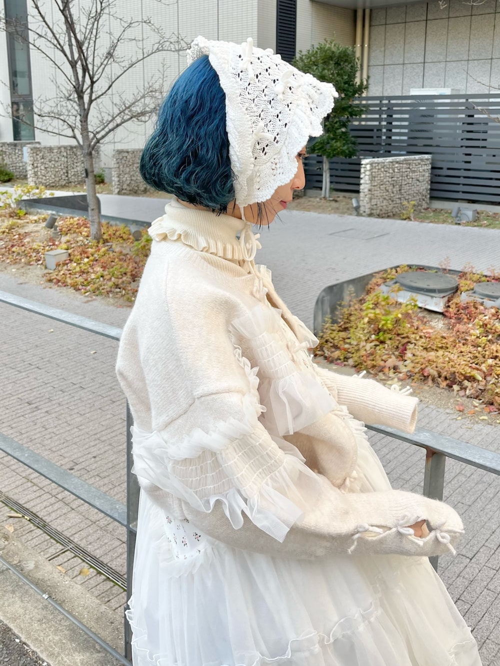 ホワイト系のニット/セーター、ホワイト系のカーディガン/ボレロ、ホワイト系のワンピースを着用したレディースの冬コーディネートの7枚目の写真