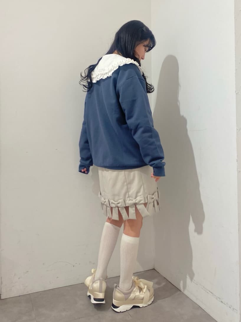 ホワイト系のシャツ/ブラウス、ベージュ系のスカート、ホワイト系のスニーカーを着用したレディースの冬コーディネートの2枚目の写真