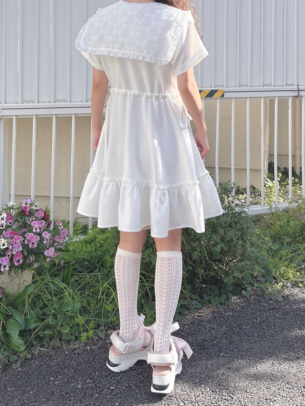 ホワイト系のワンピース、ピンク系のサンダルを着用したレディースの春コーディネートの5枚目の写真