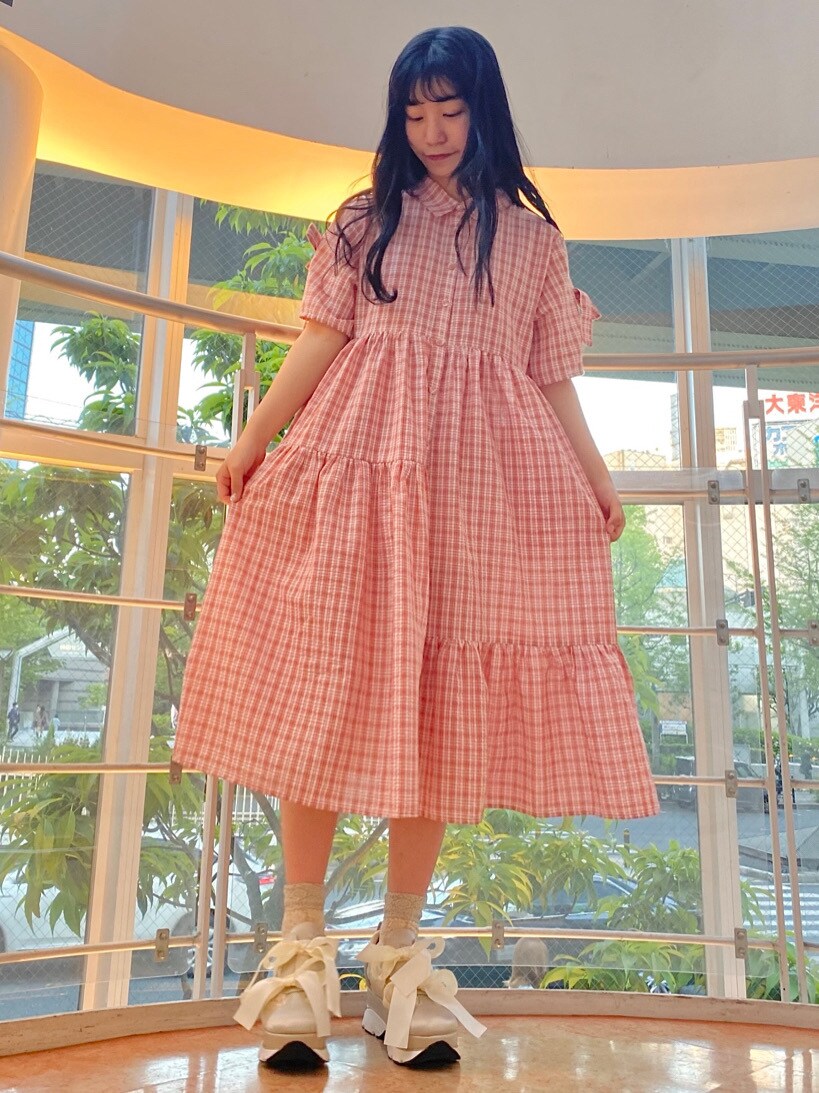 ピンク系のワンピースを着用したレディースの春コーディネートの2枚目の写真