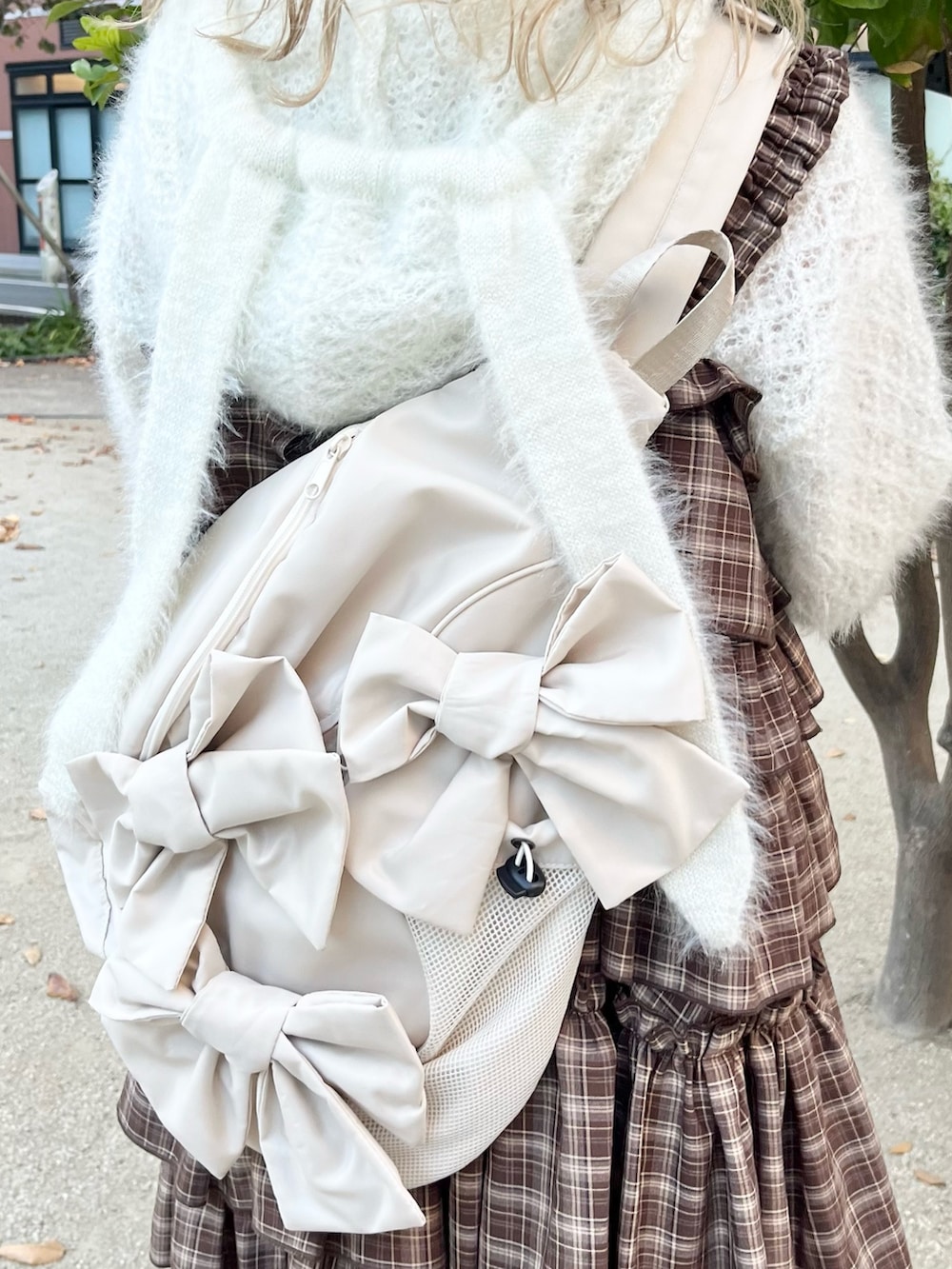 ホワイト系のニット/セーター、ブラウン系のワンピース、ベージュ系のショルダーバッグを着用したレディースの秋コーディネートの9枚目の写真