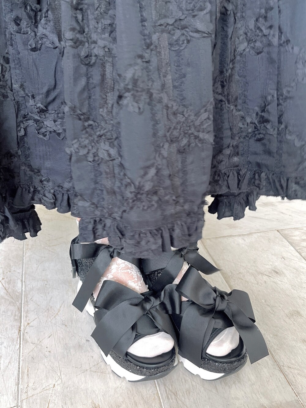 ホワイト系のシャツ/ブラウス、ブラック系のスカート、ブラック系のサンダルを着用したレディースの春コーディネートの9枚目の写真