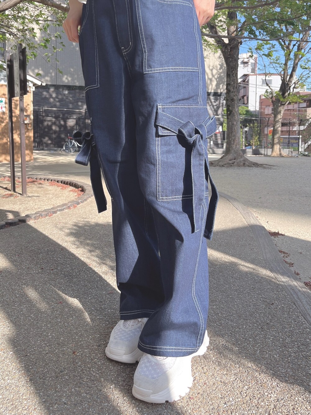 ホワイト系のTシャツ/カットソー、ブルー系のデニムパンツ、ホワイト系のスニーカーを着用したレディースの春コーディネートの5枚目の写真