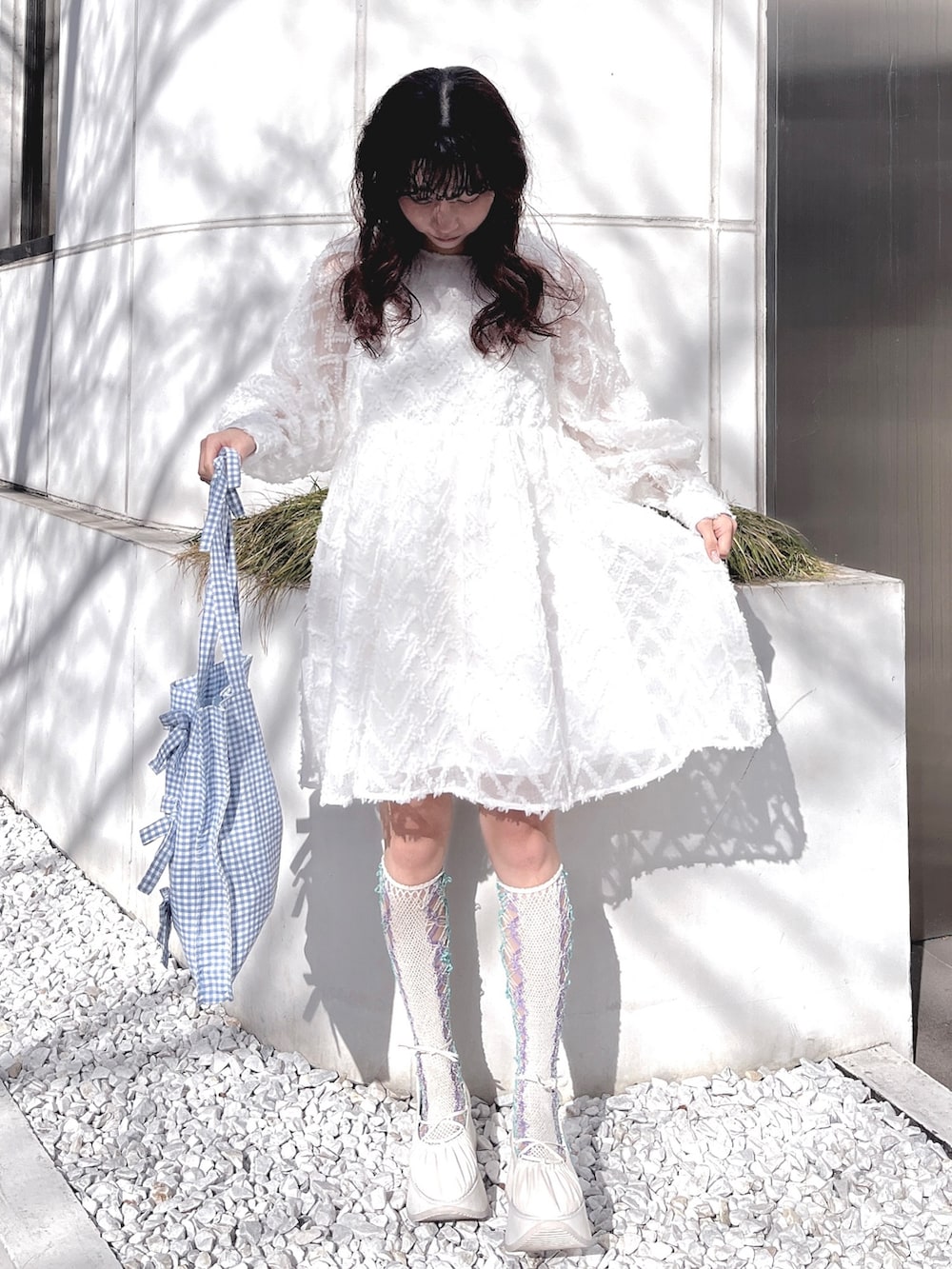 ホワイト系のワンピース、ブルー系のトートバッグ、ホワイト系のバレエシューズを着用したレディースの冬コーディネートの2枚目の写真