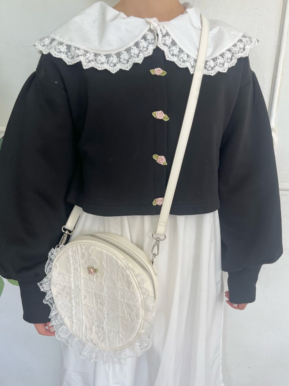 ホワイト系のワンピース、ブラック系のカーディガン/ボレロ、ホワイト系のショルダーバッグを着用したレディースの秋コーディネートの7枚目の写真