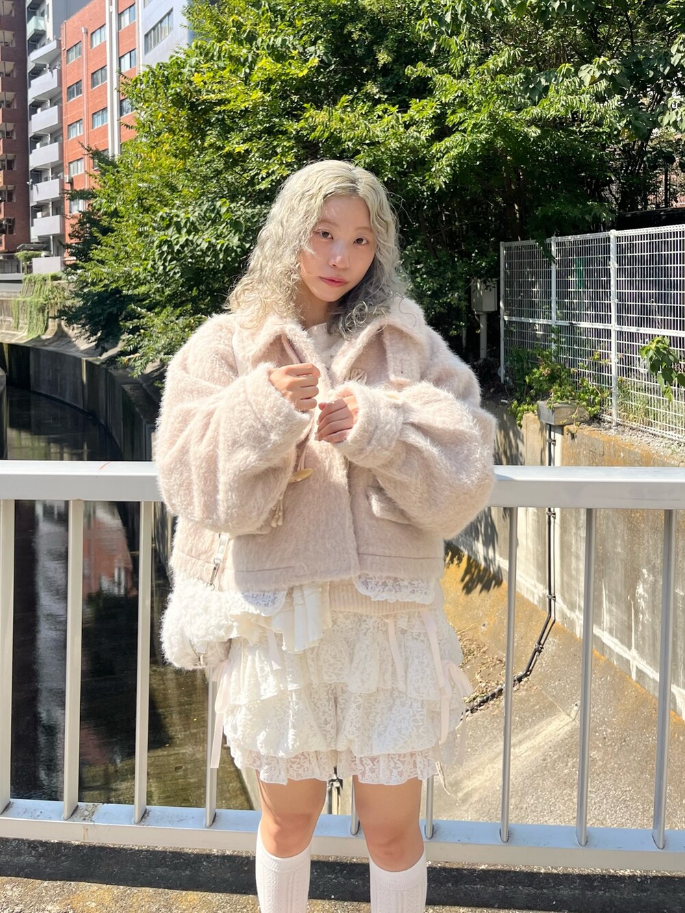 ピンク系のダッフルコート、ホワイト系のニット/セーター、ホワイト系のその他パンツを着用したレディースの秋コーディネートの5枚目の写真