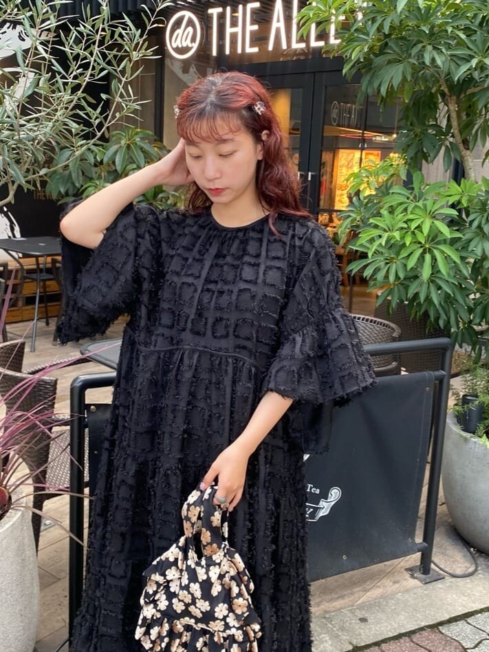 ブラック系のワンピース、ブラック系のパンプス、その他のハンドバッグを着用したレディースの秋コーディネートの4枚目の写真