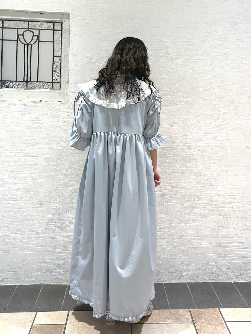 ブルー系のワンピース、シルバー系のパンプス、ホワイト系の付け襟を着用したレディースの春コーディネートの2枚目の写真