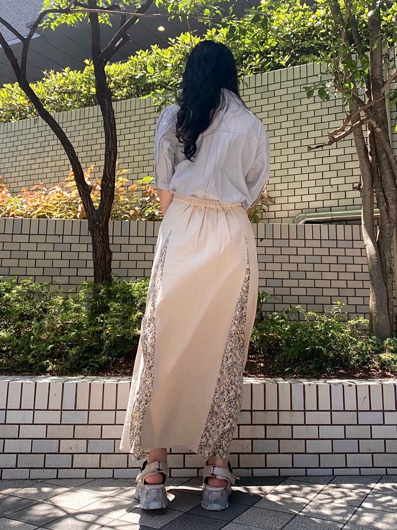 ブルー系のシャツ/ブラウス、ベージュ系のスカート、ホワイト系のサンダルを着用したレディースの春コーディネートの2枚目の写真