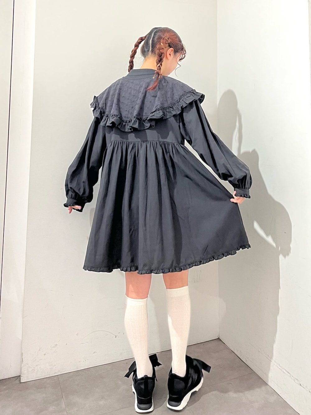 ブラック系のワンピース、ブラック系のスニーカーを着用したレディースの冬コーディネートの2枚目の写真