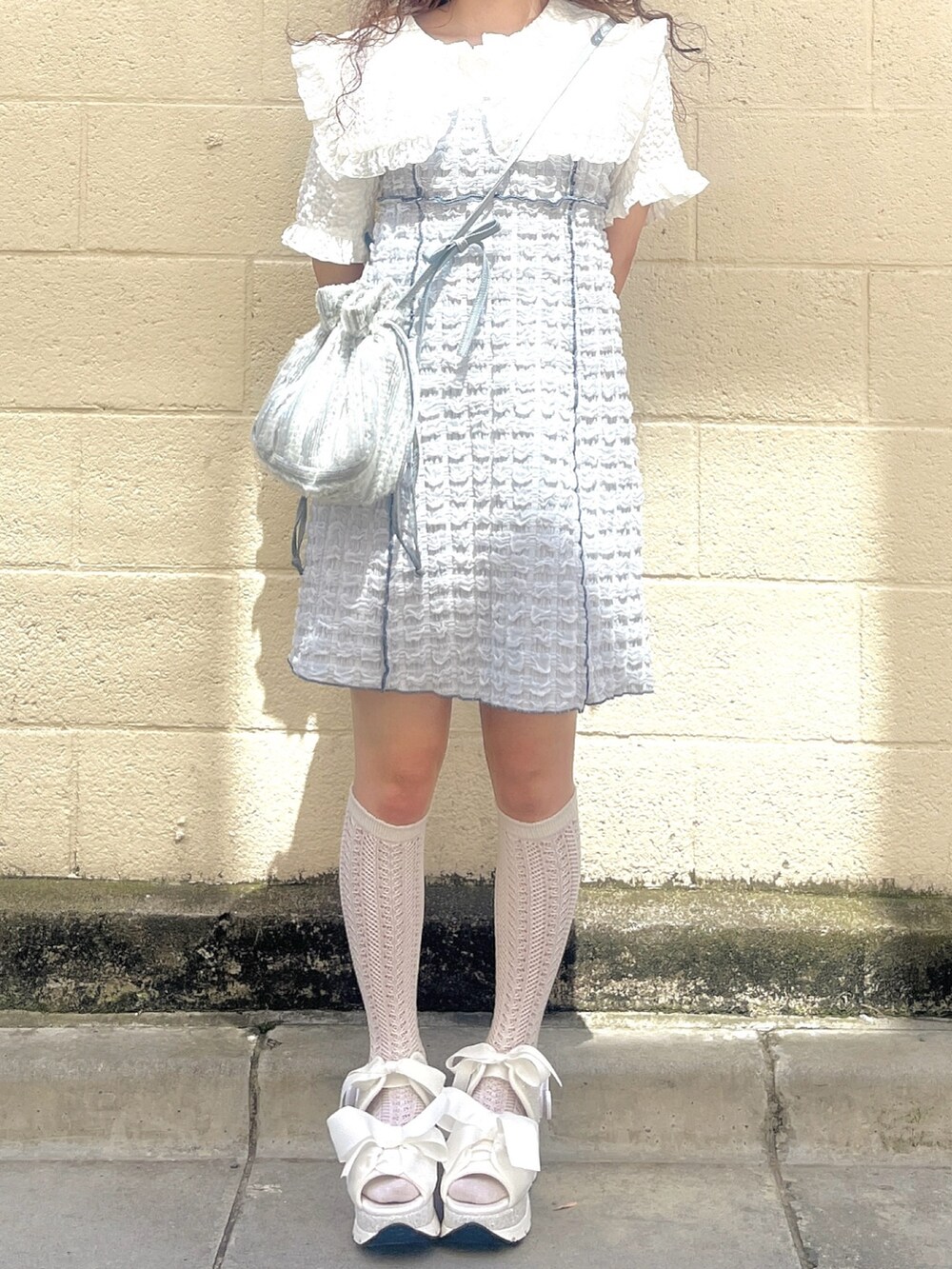 ブルー系のワンピース、ホワイト系のシャツ/ブラウス、ブルー系のショルダーバッグを着用したレディースの春コーディネートの4枚目の写真