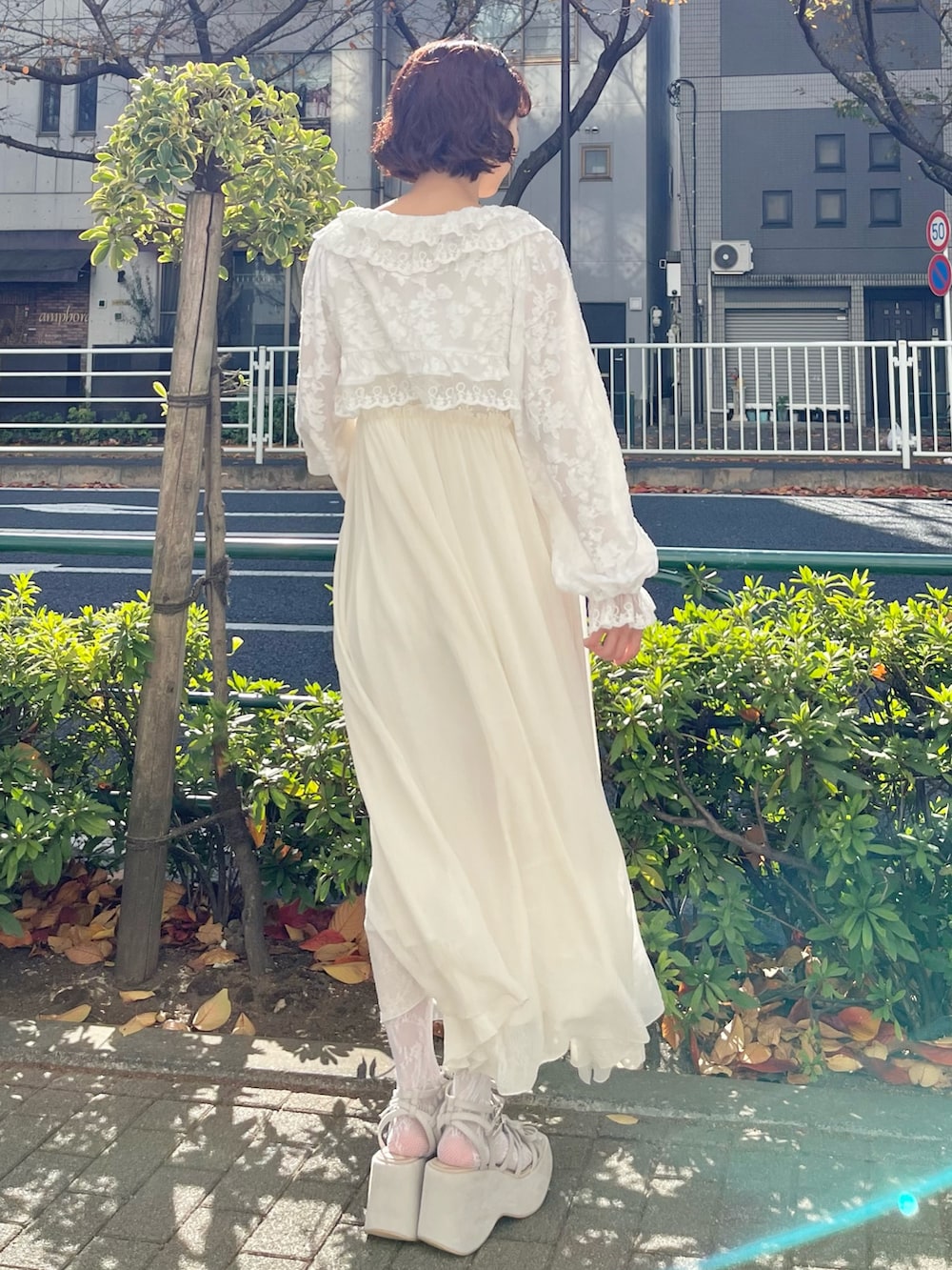 ホワイト系のカーディガン/ボレロ、ホワイト系のワンピース、ベージュ系のサンダルを着用したレディースの冬コーディネートの3枚目の写真