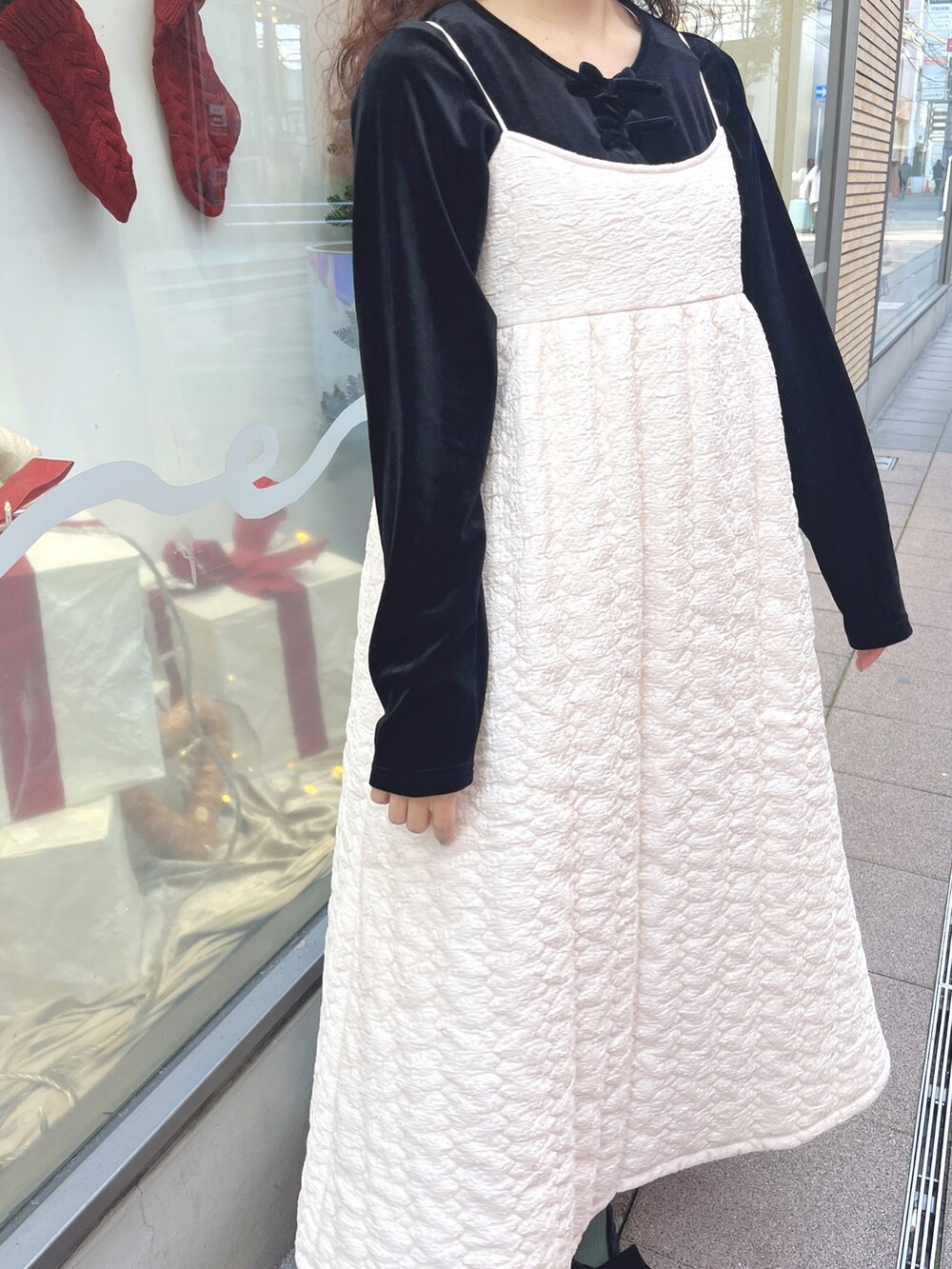 ピンク系のチェスターコート、ブラック系のカーディガン/ボレロ、ホワイト系のワンピースを着用したレディースの冬コーディネートの7枚目の写真