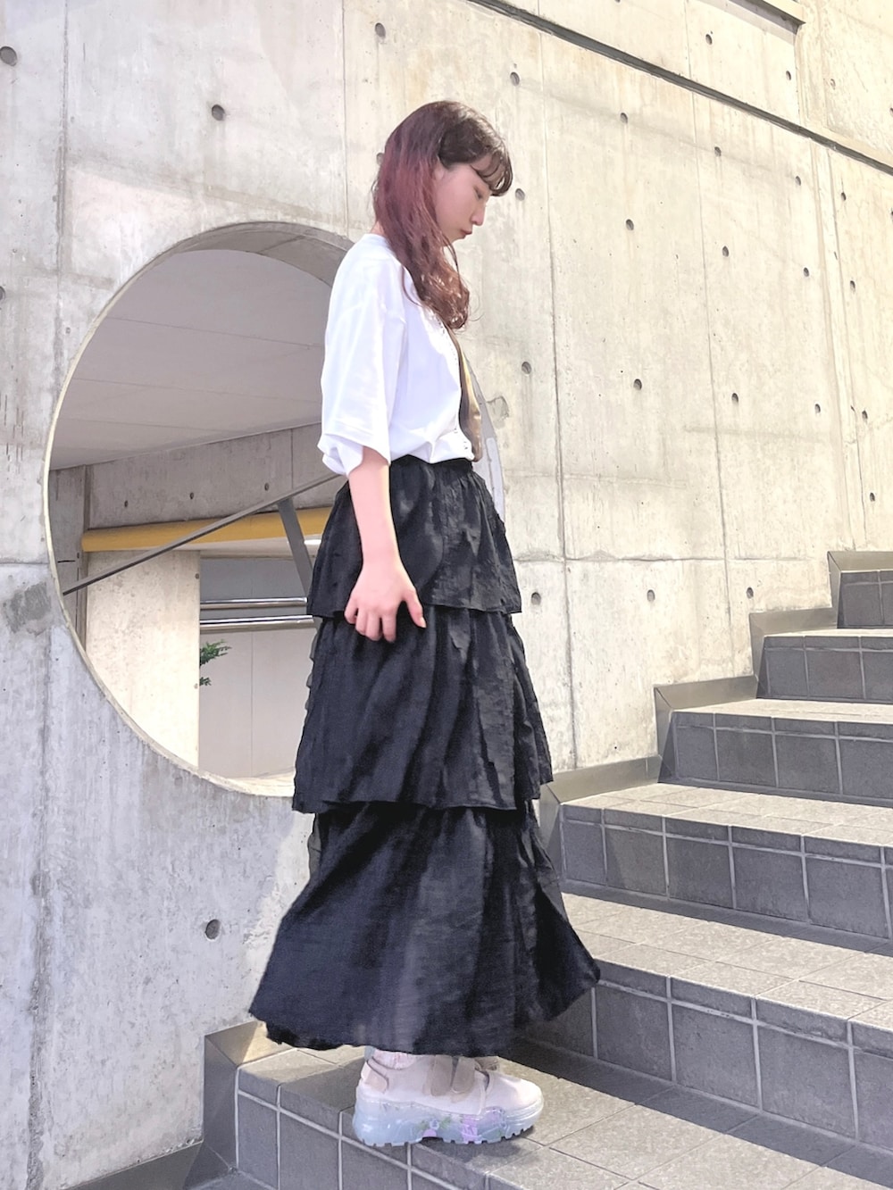 ホワイト系のTシャツ/カットソー、ブラック系のスカート、ベージュ系のスニーカーを着用したレディースの夏コーディネートの2枚目の写真