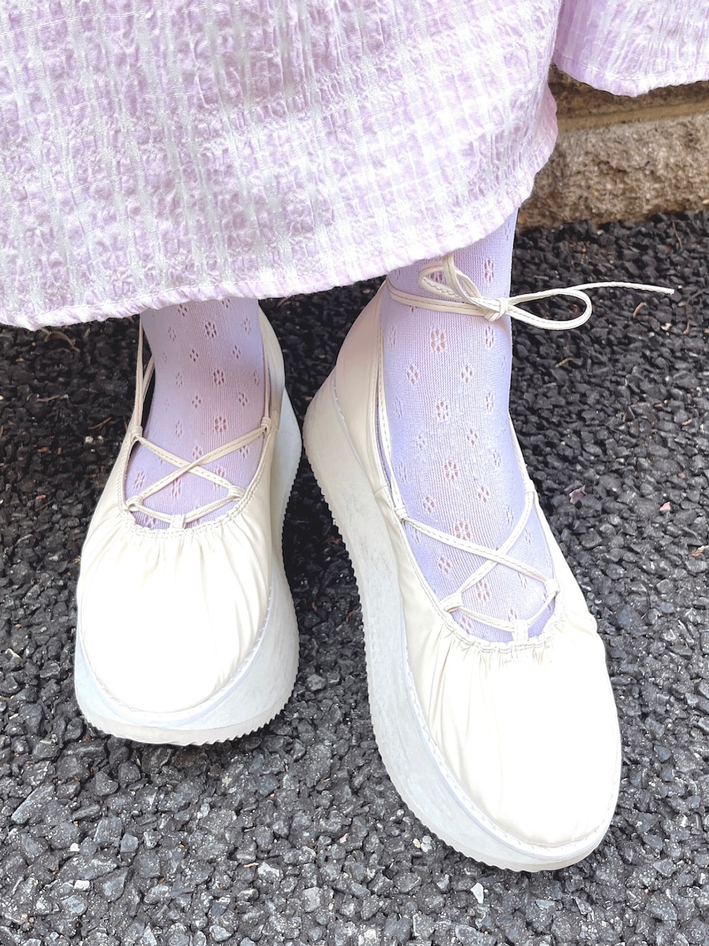 パープル系のワンピース、ホワイト系のトートバッグ、ホワイト系のバレエシューズを着用したレディースの冬コーディネートの9枚目の写真