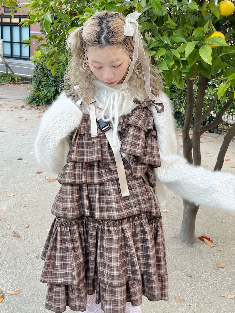 ホワイト系のニット/セーター、ブラウン系のワンピース、ベージュ系のショルダーバッグを着用したレディースの秋コーディネートの5枚目の写真