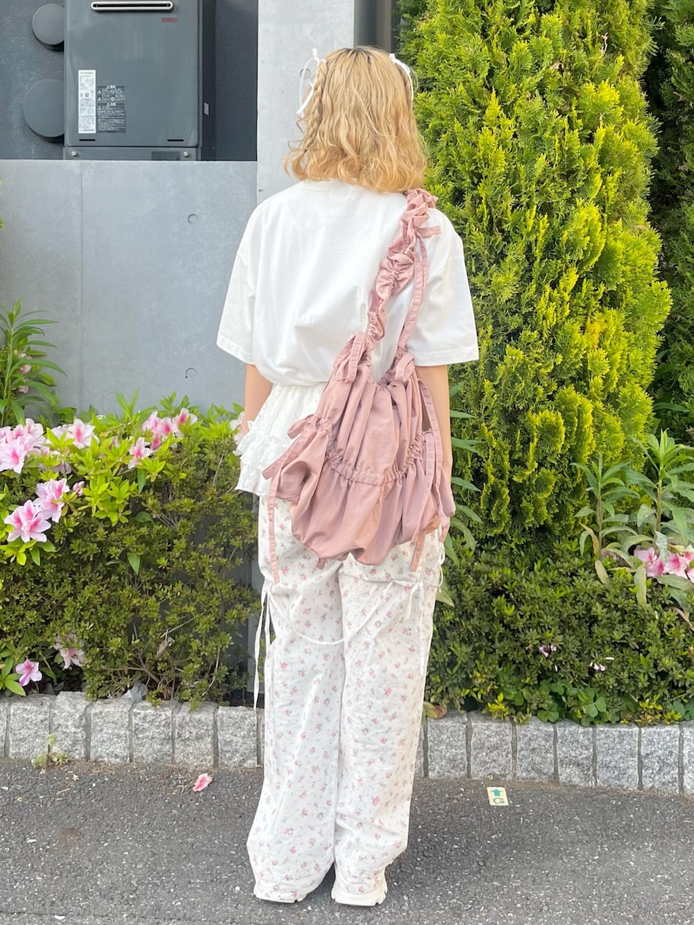 ホワイト系のTシャツ/カットソー、ホワイト系のスラックス、ピンク系のトートバッグを着用したレディースの春コーディネートの3枚目の写真