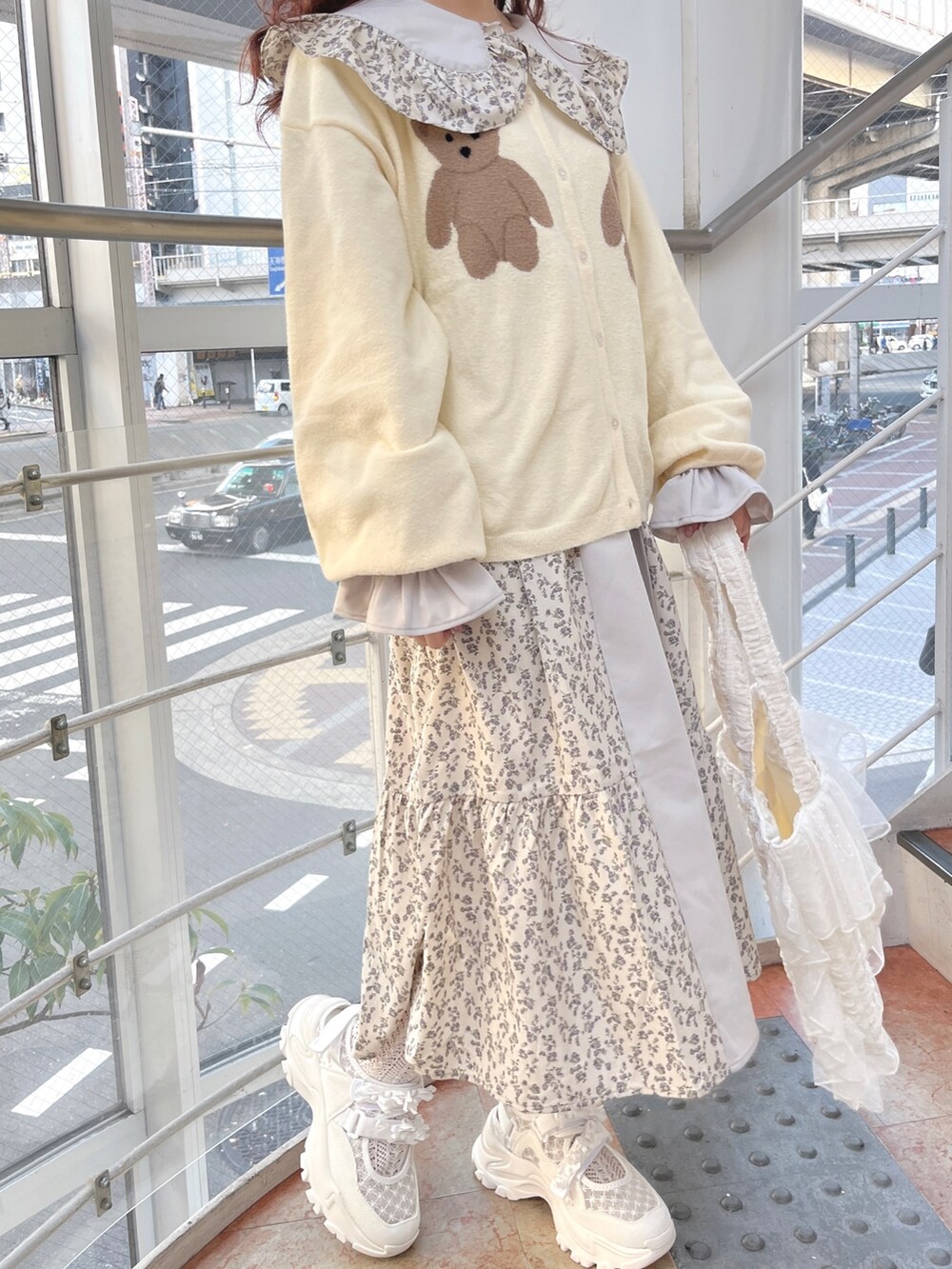 ブルー系のワンピース、ホワイト系のカーディガン/ボレロ、ホワイト系のトートバッグを着用したレディースの冬コーディネートの6枚目の写真