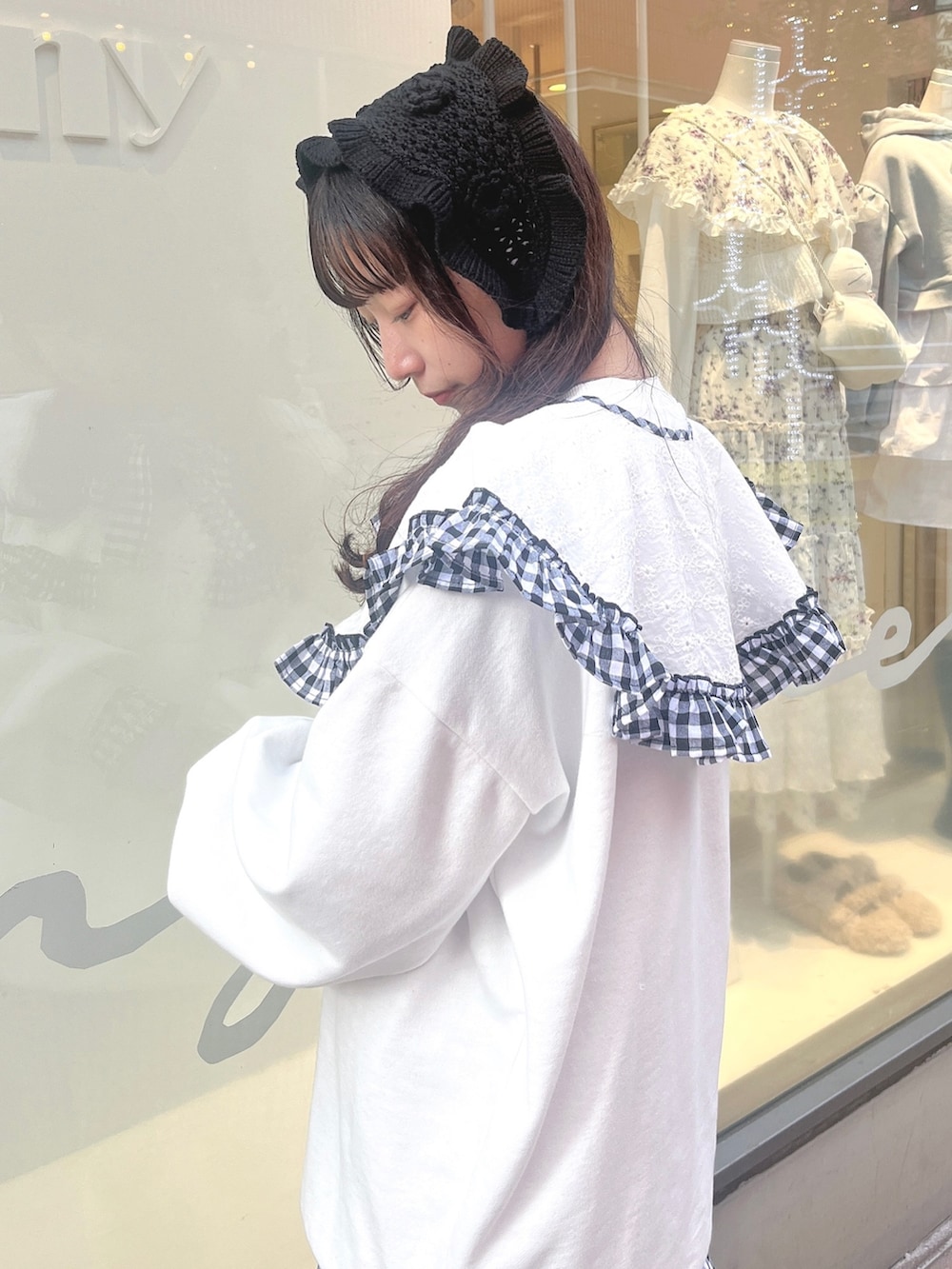 ホワイト系のスウェット、ブラック系のワンピース、ブラック系のスニーカーを着用したレディースの冬コーディネートの6枚目の写真