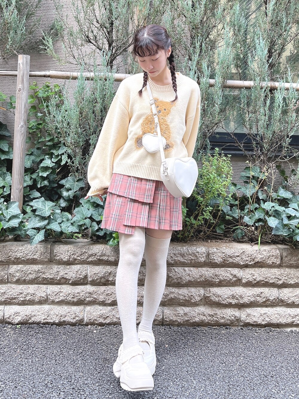 ホワイト系のニット/セーター、ホワイト系のショルダーバッグ、ピンク系のスカートを着用したレディースの秋コーディネートの2枚目の写真