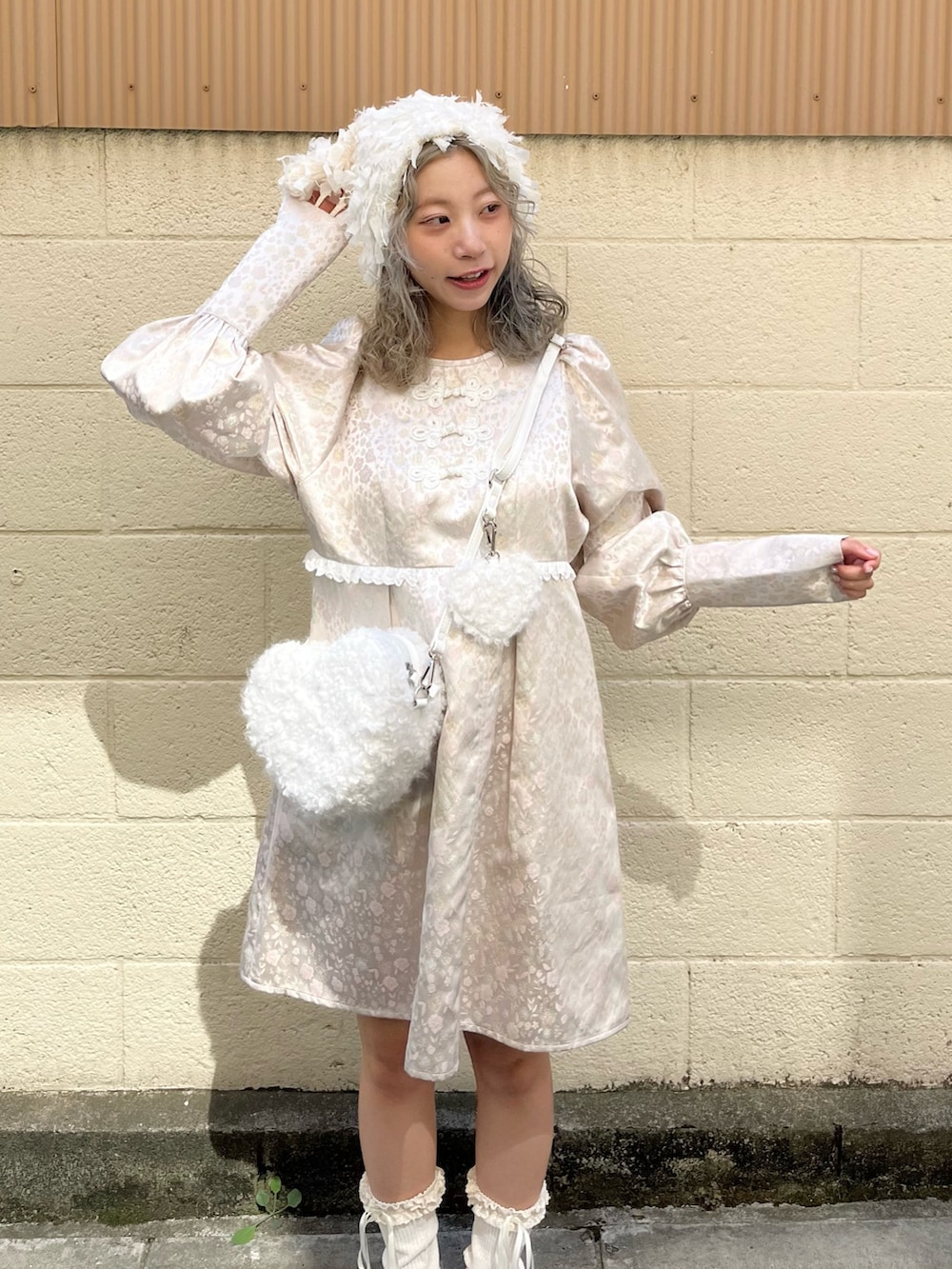 ピンク系のワンピース、ホワイト系のショルダーバッグ、ホワイト系のスニーカーを着用したレディースの秋コーディネートの4枚目の写真