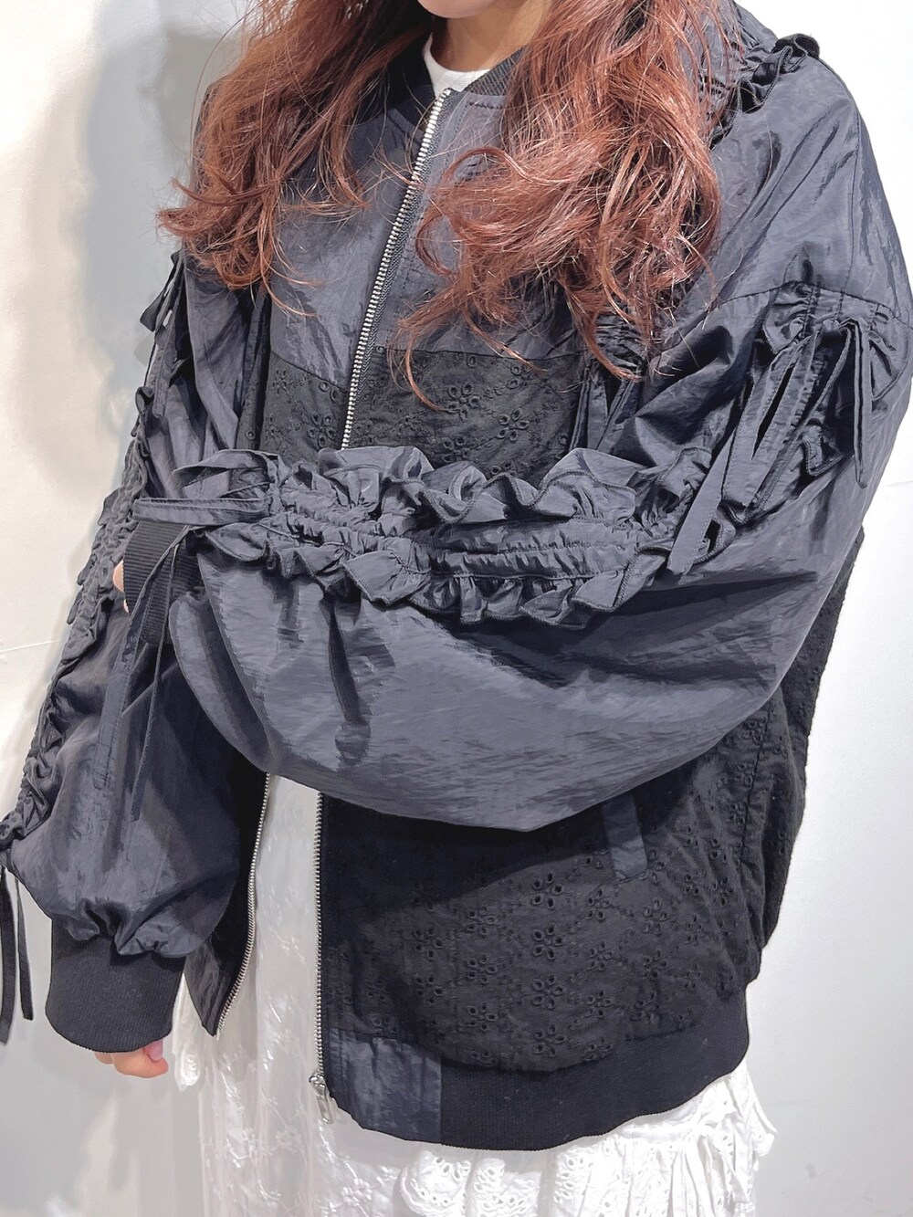 ブラック系のブルゾン、ホワイト系のTシャツ/カットソー、ホワイト系のスカートを着用したレディースの冬コーディネートの6枚目の写真