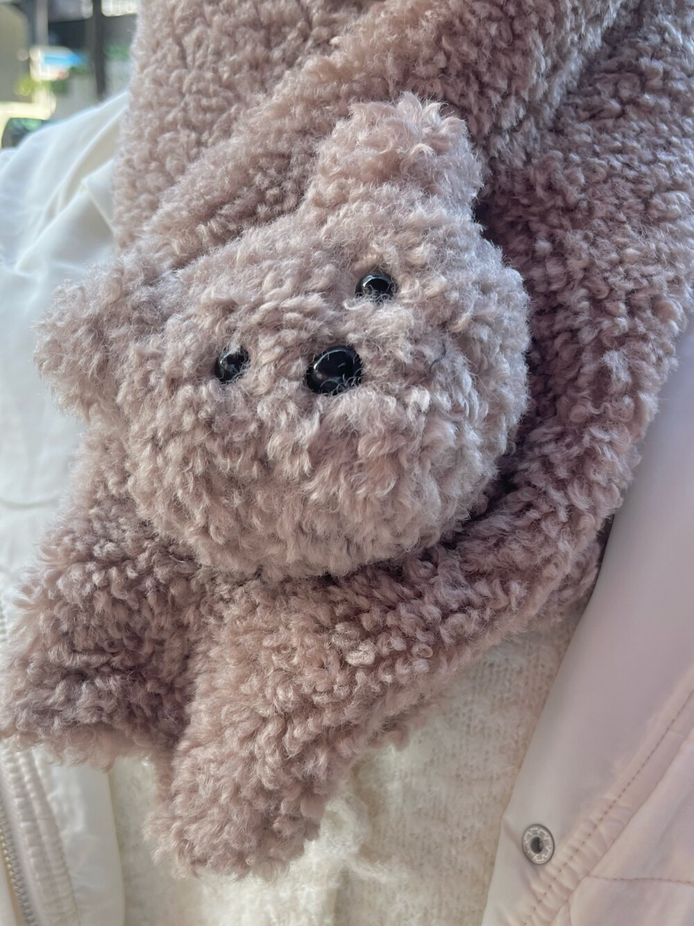 ホワイト系のカーディガン/ボレロ、ホワイト系のダウンジャケット/コート、ブラウン系のスカートを着用したレディースの冬コーディネートの6枚目の写真