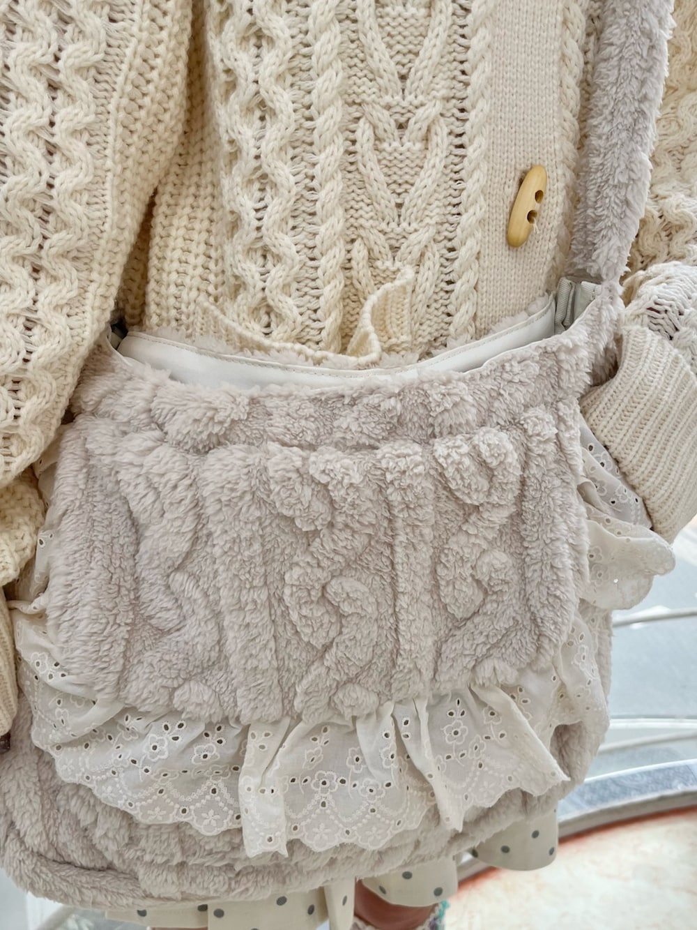 ホワイト系のカーディガン/ボレロ、ホワイト系のスカート、ベージュ系のショルダーバッグを着用したレディースの冬コーディネートの8枚目の写真