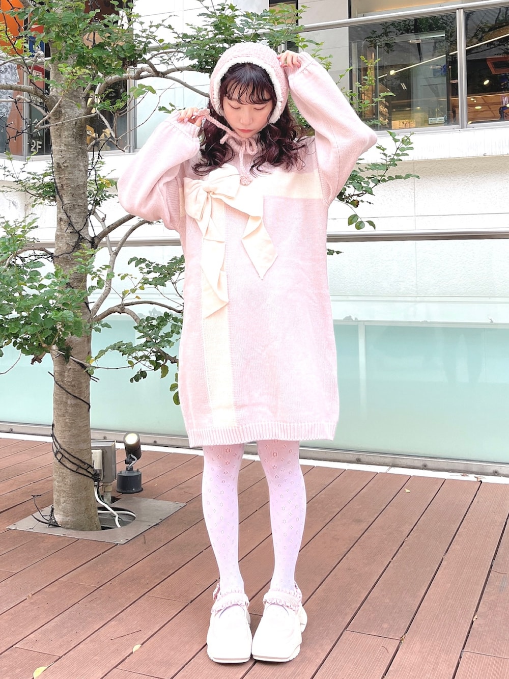 ピンク系のワンピース、ピンク系のスニーカー、ピンク系のイヤーマフを着用したレディースの秋コーディネートの2枚目の写真