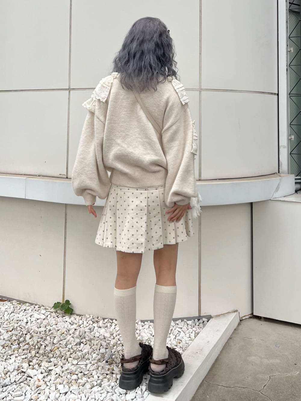 ホワイト系のニット/セーター、ホワイト系のスカート、ベージュ系のショルダーバッグを着用したレディースの秋コーディネートの3枚目の写真