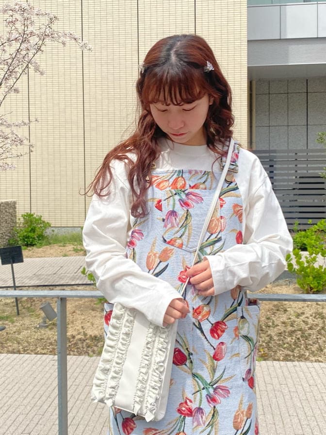 ブルー系のジャンパースカート、ホワイト系のスニーカー、ホワイト系のTシャツ/カットソーを着用したレディースの春コーディネートの4枚目の写真