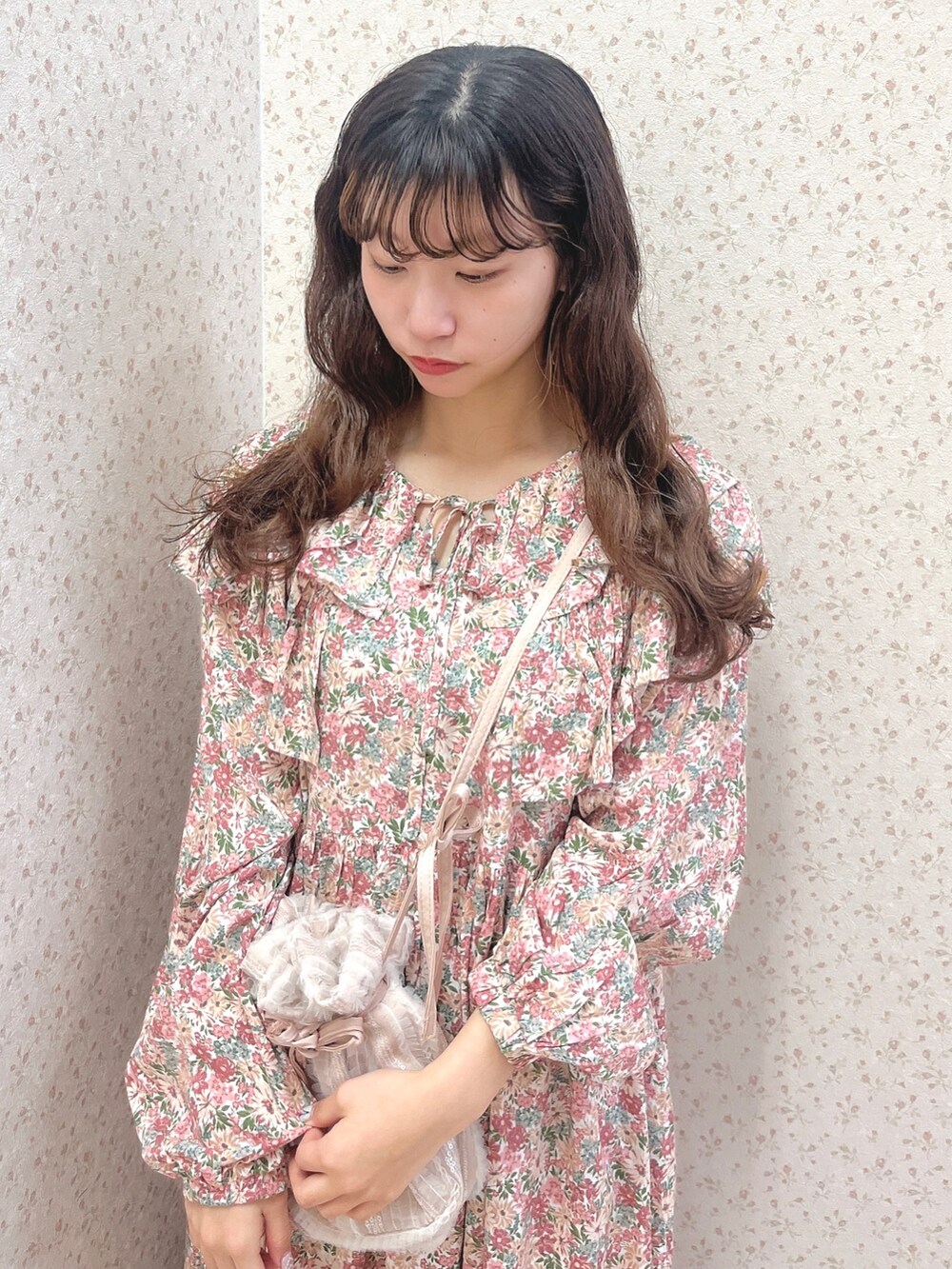 ピンク系のワンピース、ピンク系のショルダーバッグ、ホワイト系のパンプスを着用したレディースの春コーディネートの5枚目の写真