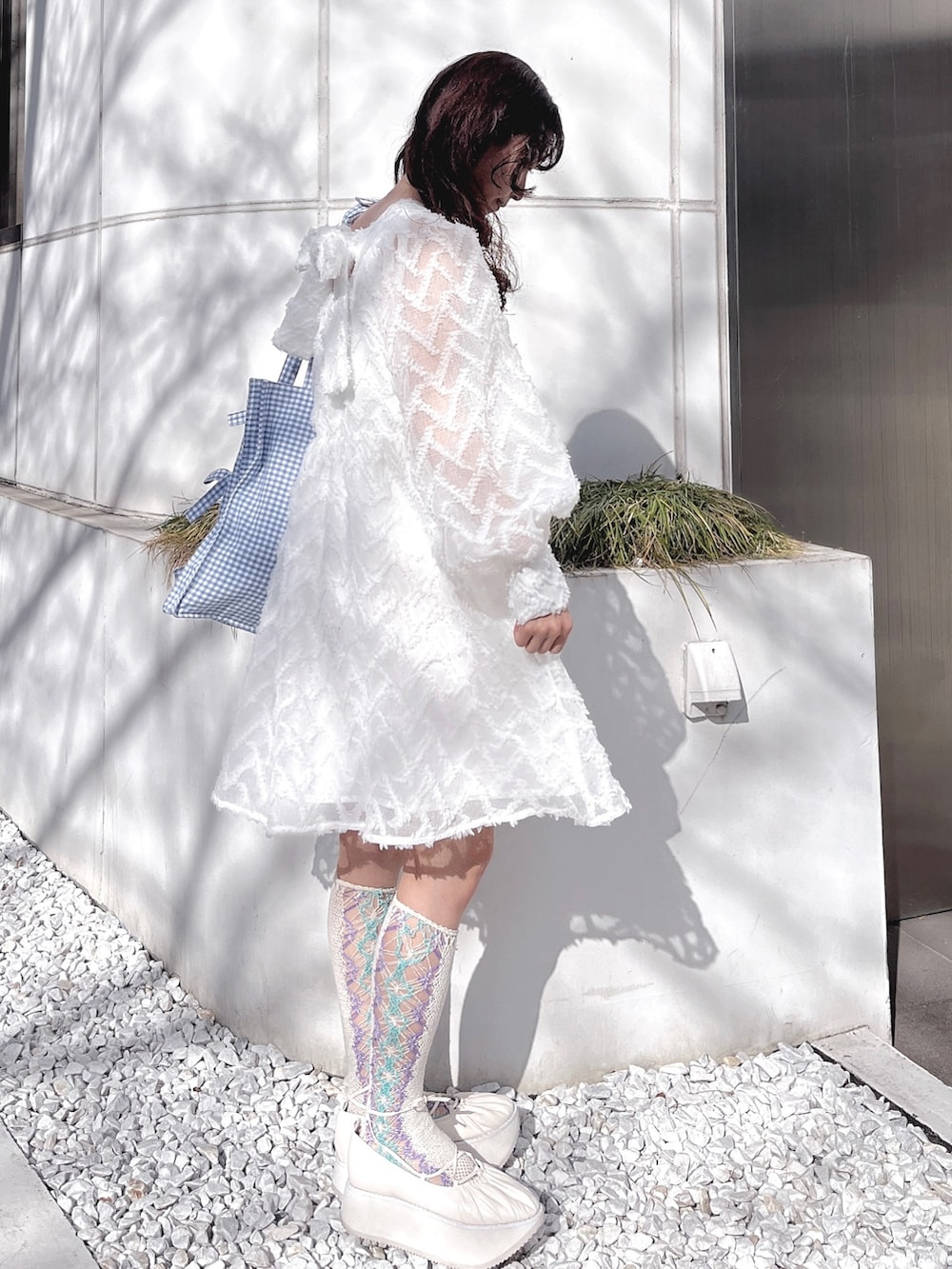 ホワイト系のワンピース、ブルー系のトートバッグ、ホワイト系のバレエシューズを着用したレディースの冬コーディネートの3枚目の写真