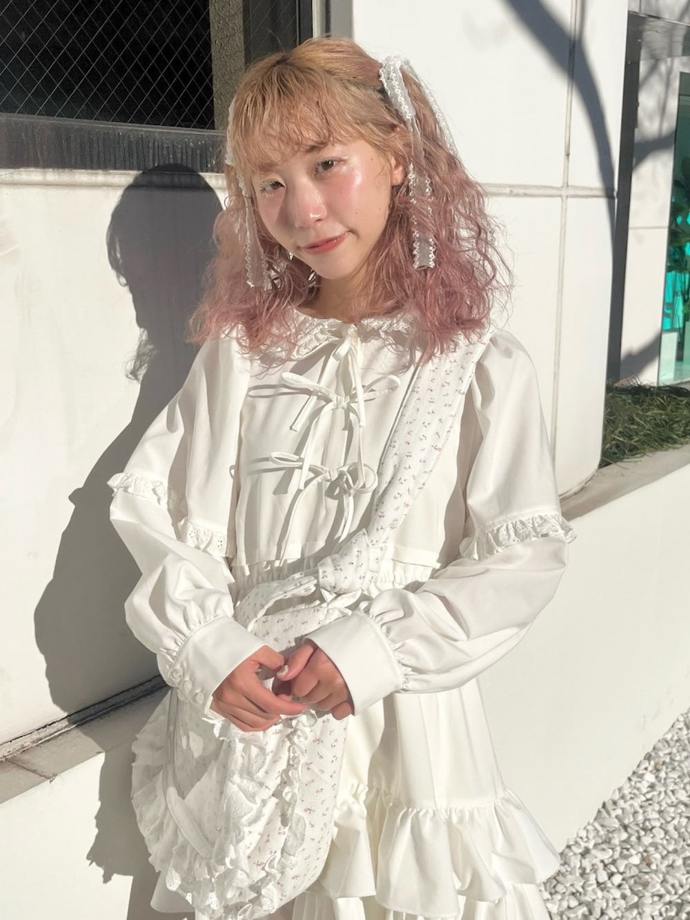 ホワイト系のワンピース、ピンク系のショルダーバッグ、ホワイト系のスニーカーを着用したレディースの冬コーディネートの5枚目の写真