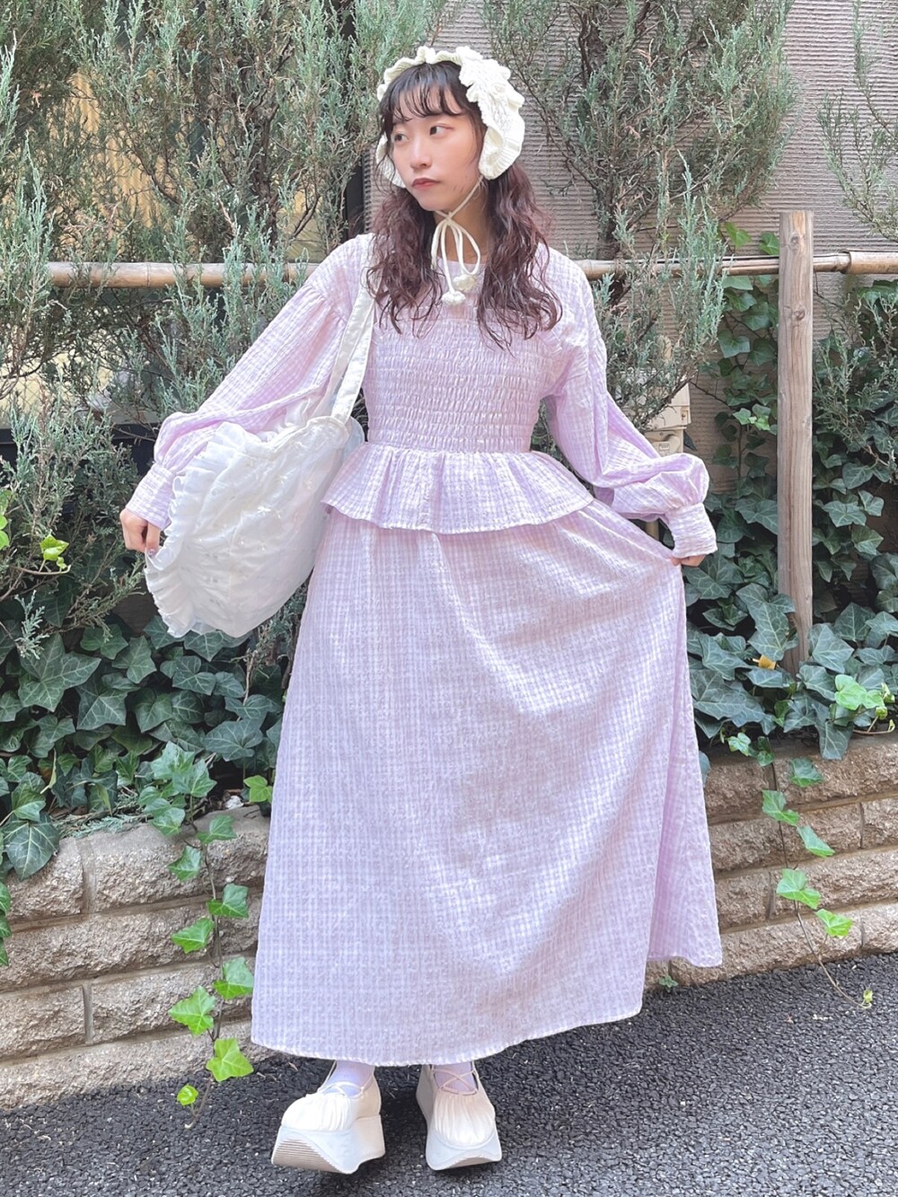 パープル系のワンピース、ホワイト系のトートバッグ、ホワイト系のバレエシューズを着用したレディースの冬コーディネートの2枚目の写真