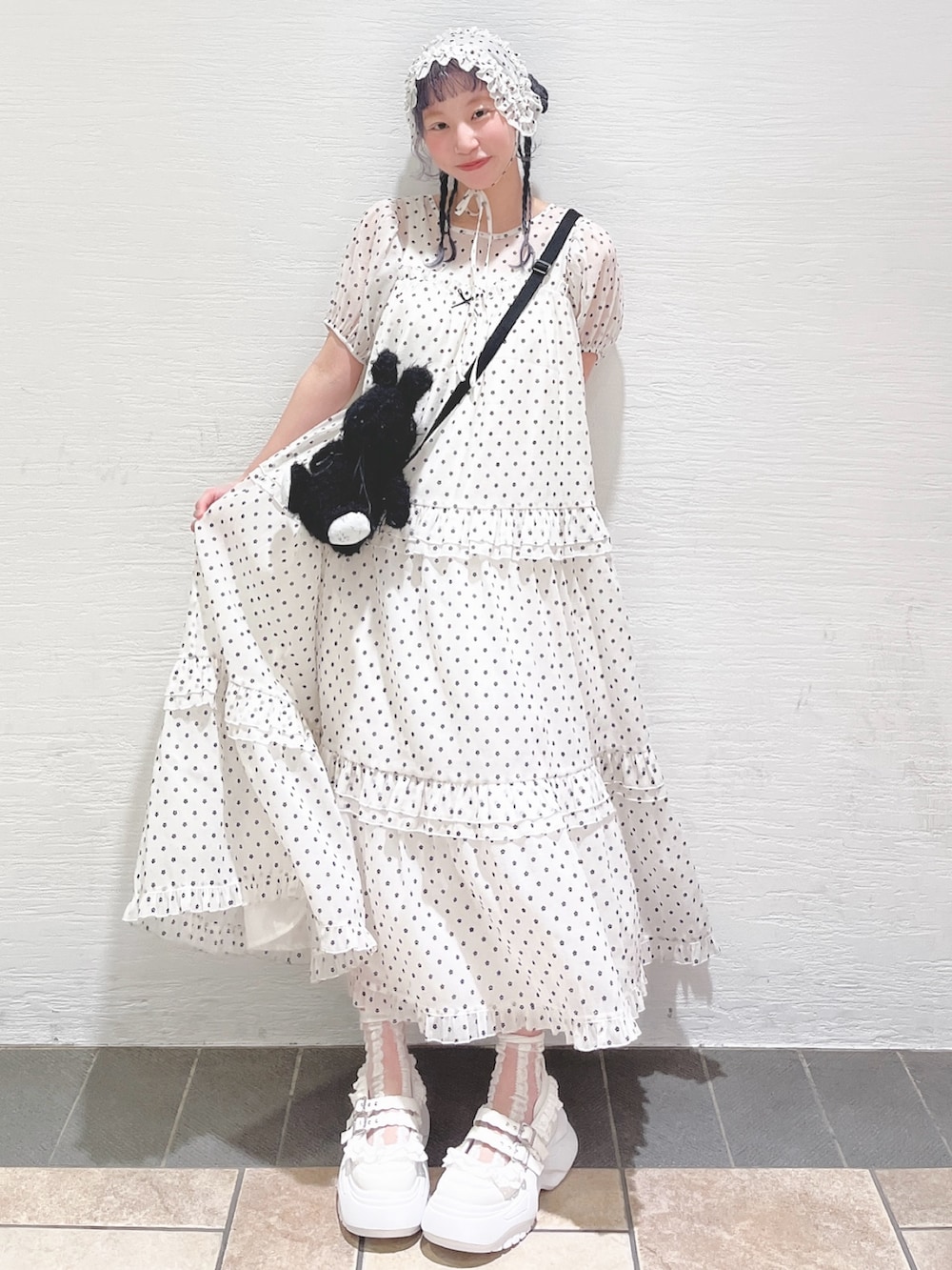 ホワイト系のワンピース、ブラック系のショルダーバッグ、ホワイト系のスニーカーを着用したレディースの春コーディネートの2枚目の写真