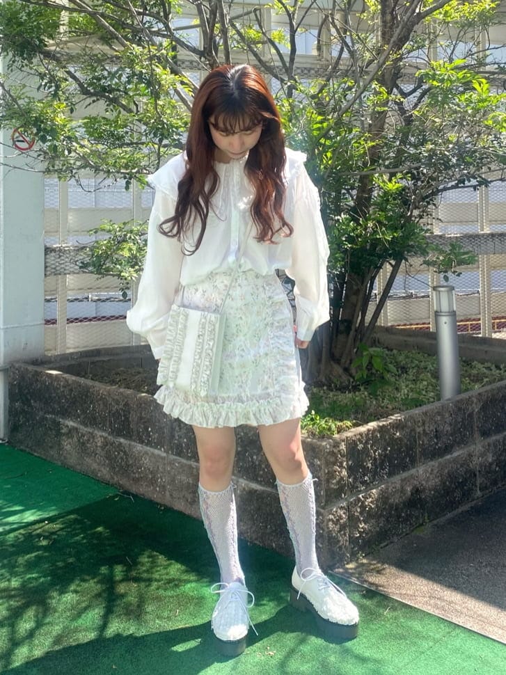 ホワイト系のショルダーバッグ、ホワイト系のシャツ/ブラウス、ピンク系のスカートを着用したレディースの春コーディネートの2枚目の写真